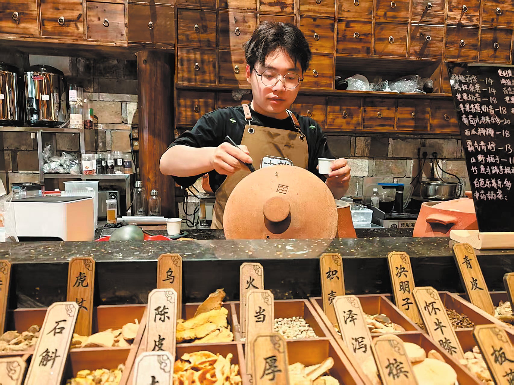 <p>Gao Lingxu tends to simmering pots of traditional Chinese medicine tea at his shop in Nanping, Fujian province</p>