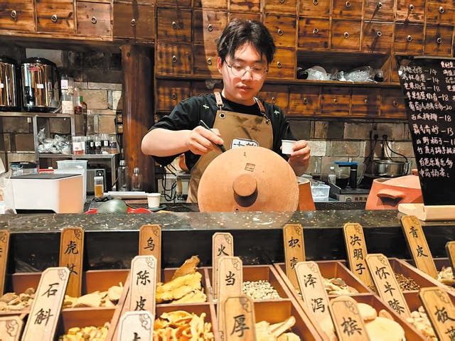 <p>Gao Lingxu tends to simmering pots of traditional Chinese medicine tea at his shop in Nanping, Fujian province</p>