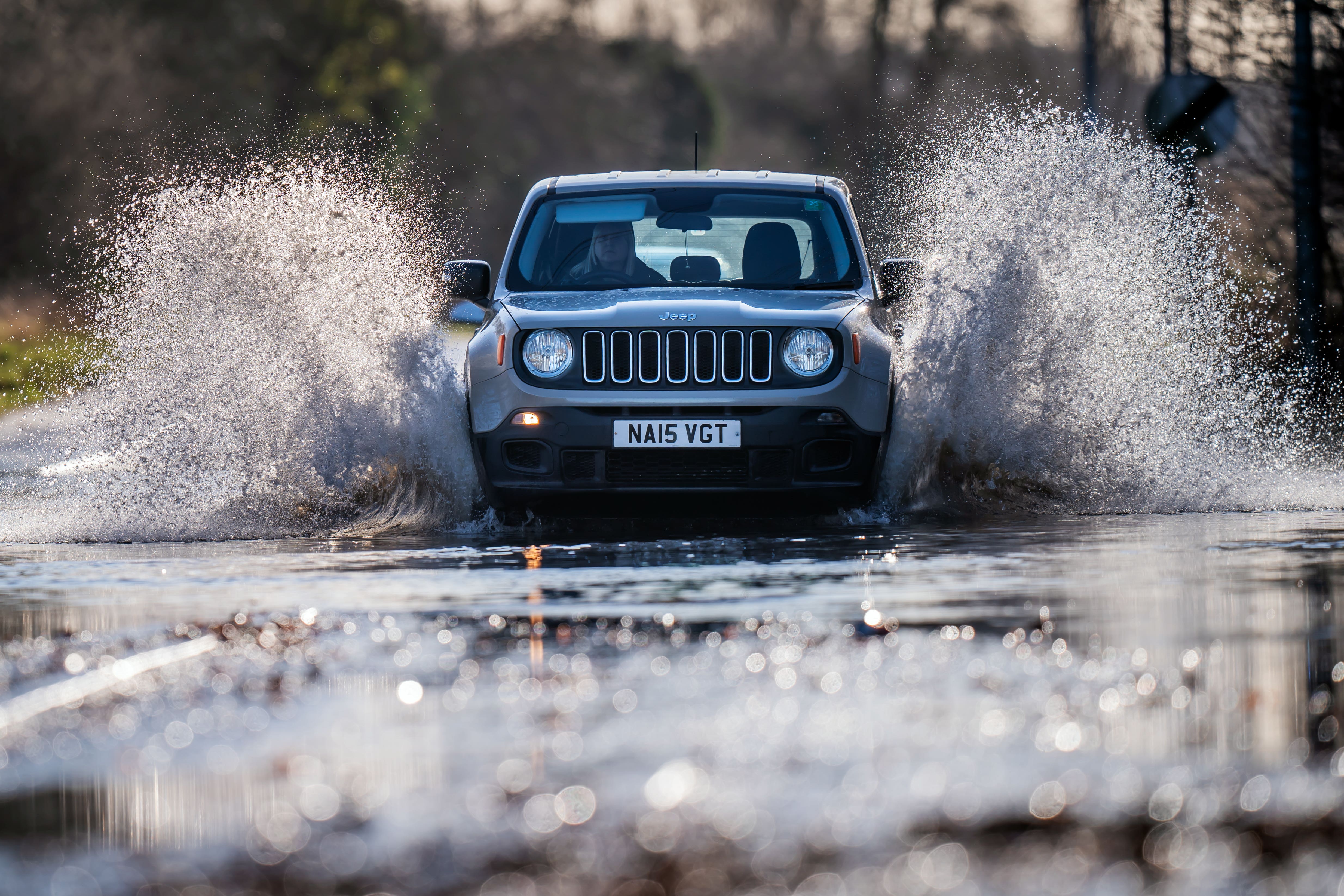 A vehicle drives through flood water. (Danny Lawson/PA)