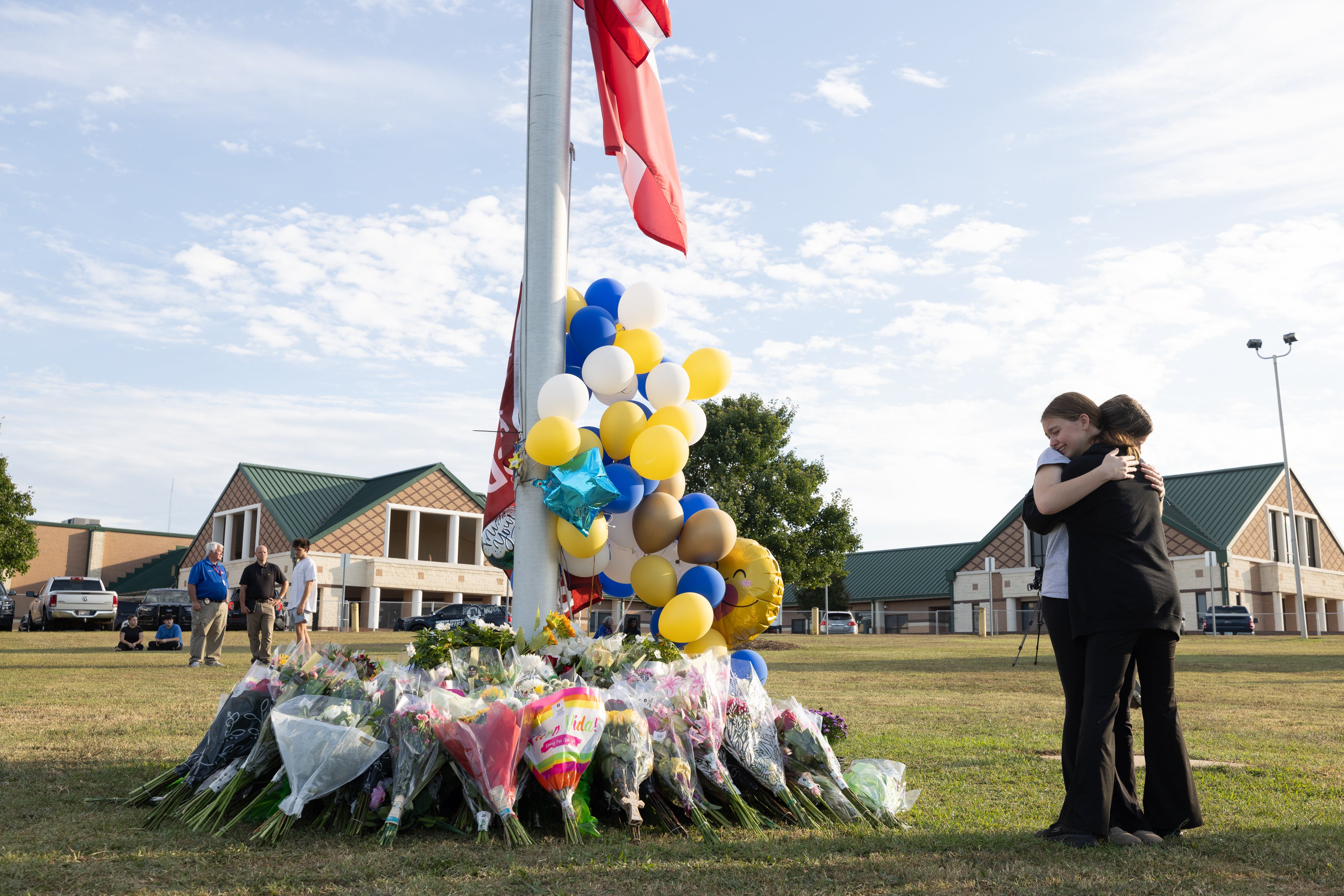 <p>Students embrace at a vigil after a school shooting</p>