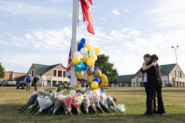 <p>Students embrace at a vigil after a school shooting</p>