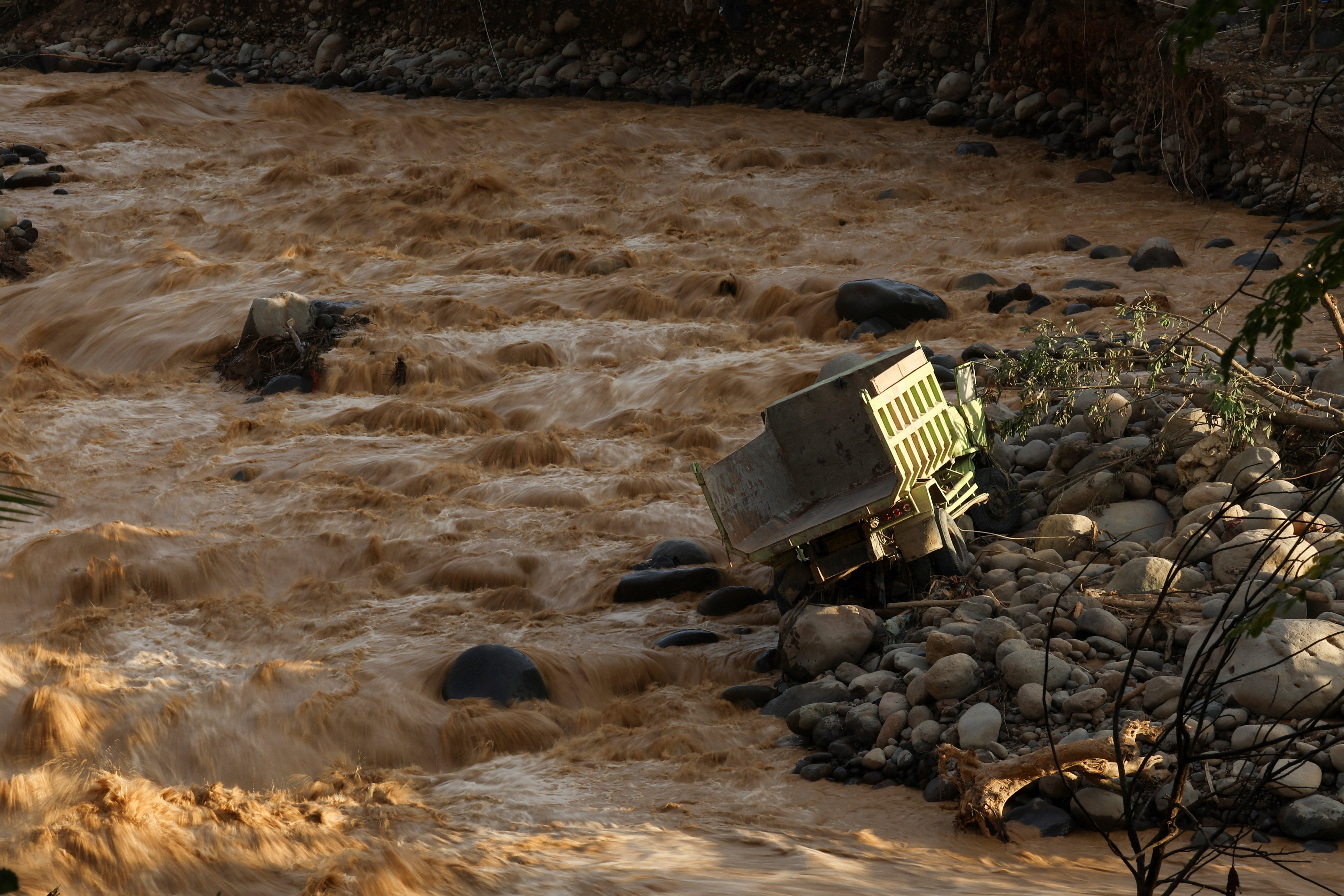 A truck is stranded in the river at an area hit by deadly flash floods following heavy rains in Padang, West Sumatra province, Indonesia, 30 November 2025