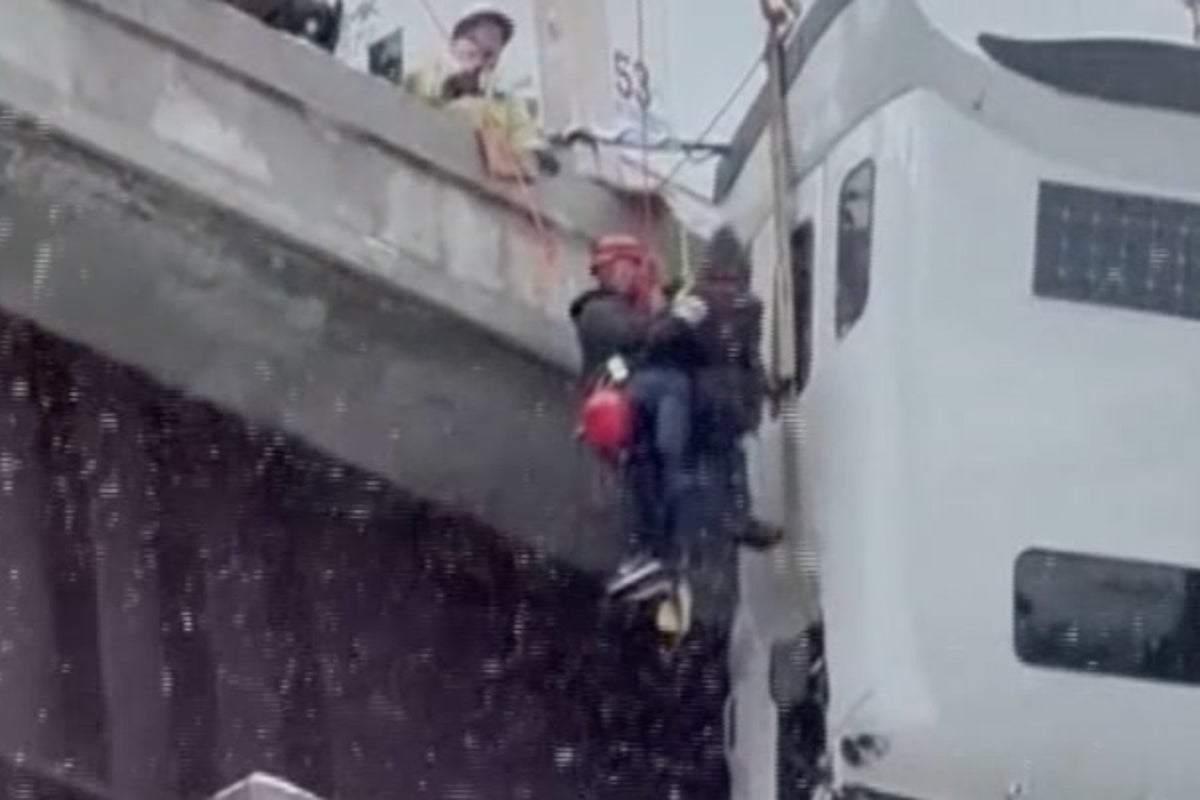 Driver stuck in truck dangling off icy bridge saved in dramatic rescue