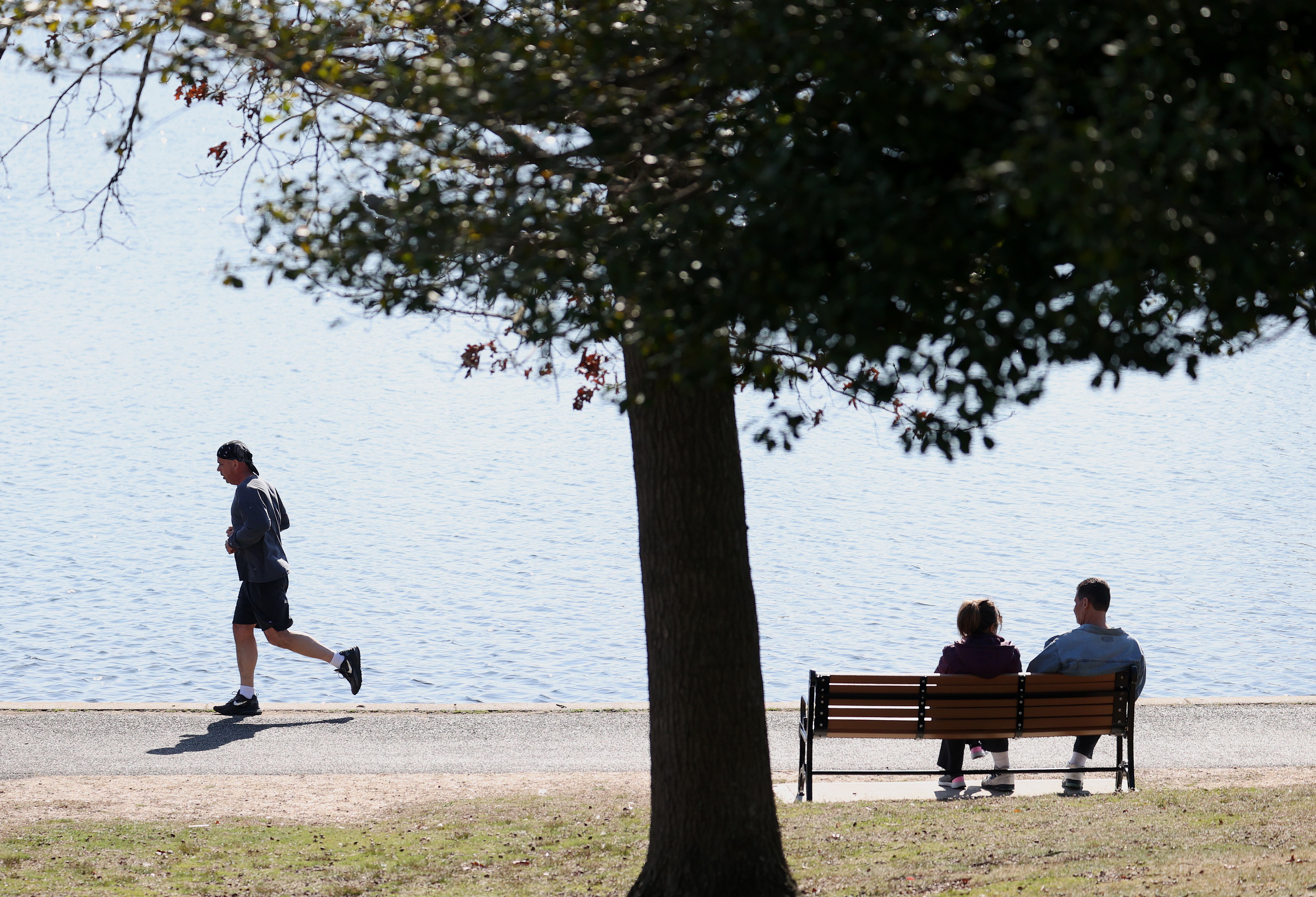 Two people sit on a park bench in East Meadow, New York. Friendship can help prevent feeling of loneliness
