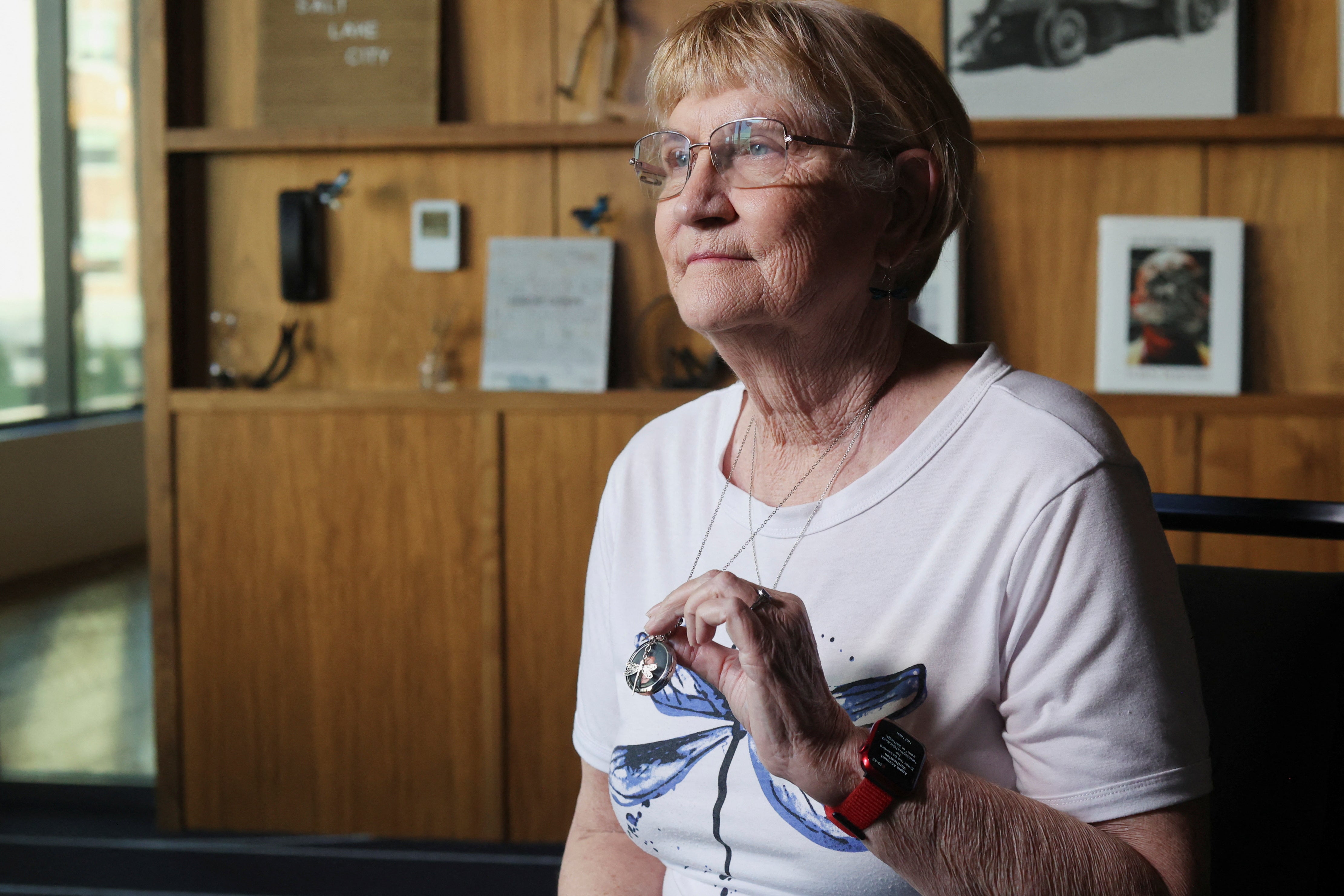 Annie Vargas holds a necklace with a picture of her son, pilot Brian Wittke, in Salt Lake City, Utah