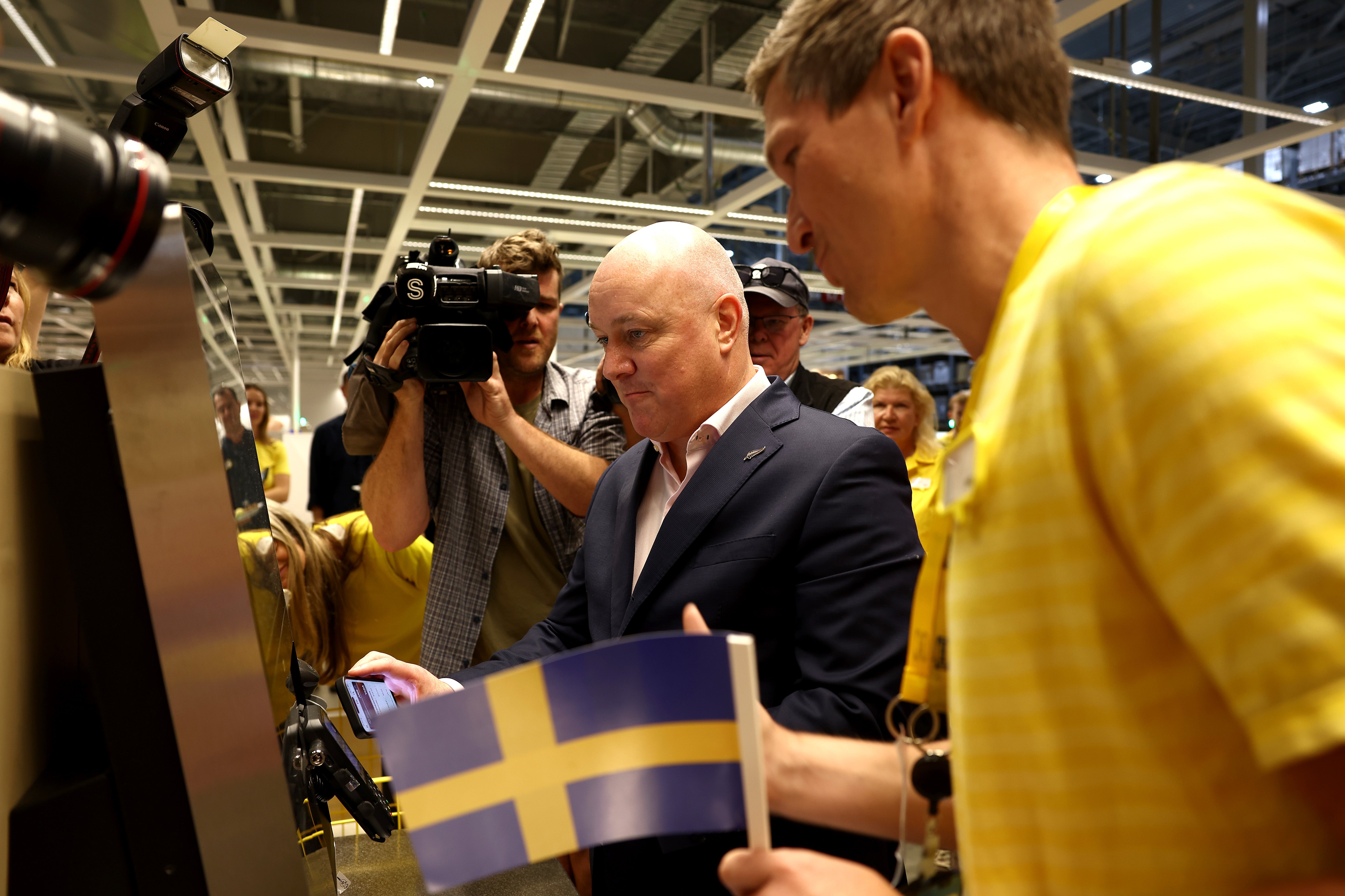 Prime Minister Christopher Luxon, centre, makes a purchase at the IKEA store