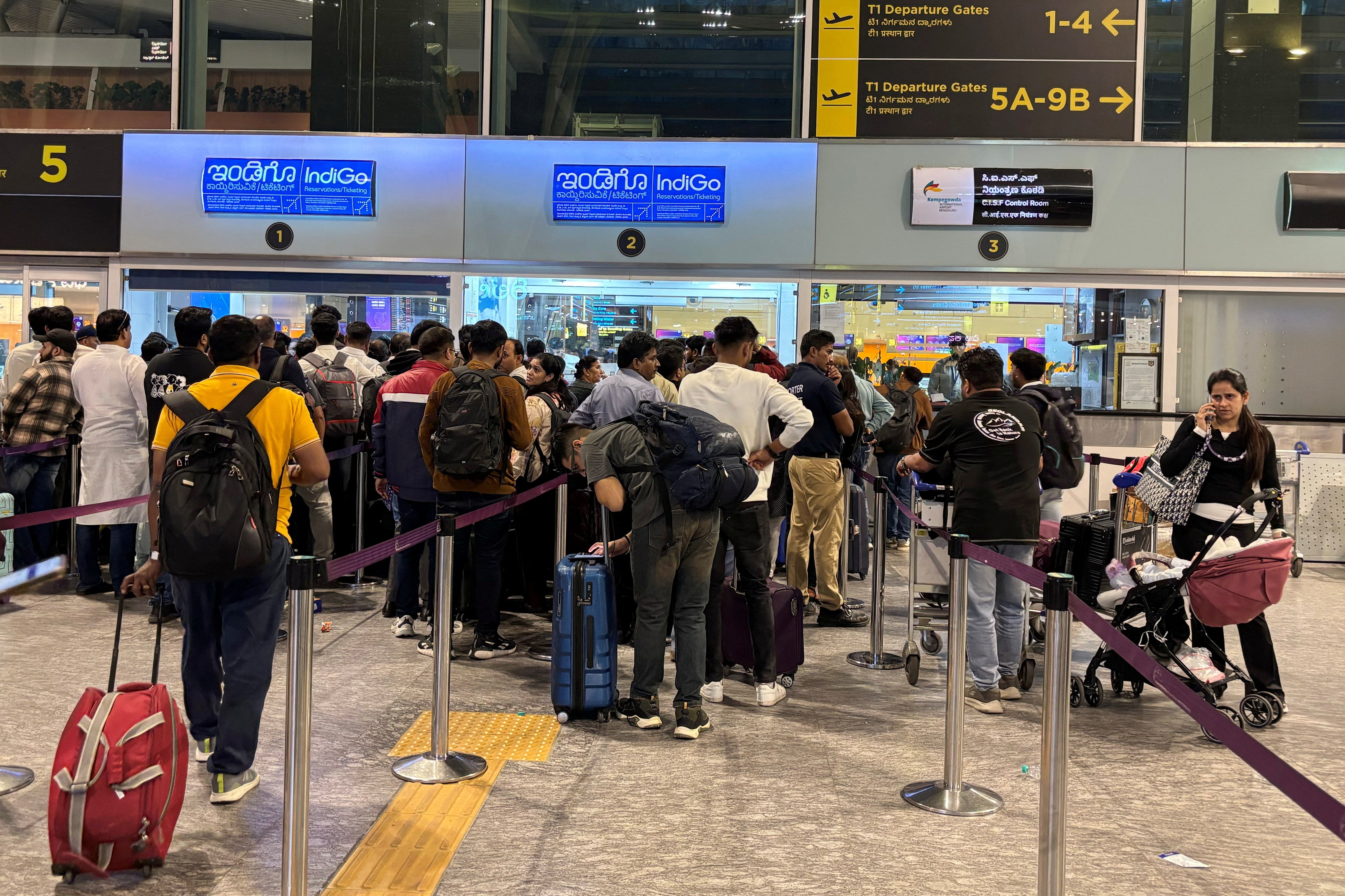 Travelers wait at IndiGo ticketing kiosks to reschedule their flights at the Bengaluru airport