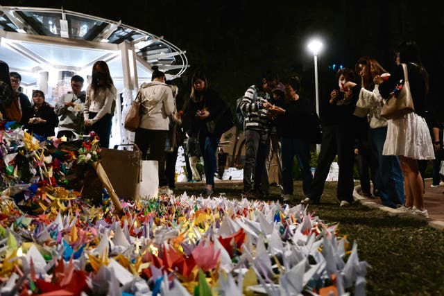 <p>Quienes están de luto doblan grullas de papel durante una vigilia celebrada frente a los bloques de departamentos de Wang Fuk Court tras el mortífero incendio del 26 de noviembre en el distrito Tai Po de Hong Kong, el 3 de diciembre de 2025. El número de víctimas mortales del peor incendio de Hong Kong en décadas ascendió a 159 tras el registro de todos los bloques de viviendas afectados, según informó la policía el 3 de diciembre, advirtiendo de que la cifra podría no ser definitiva</p>