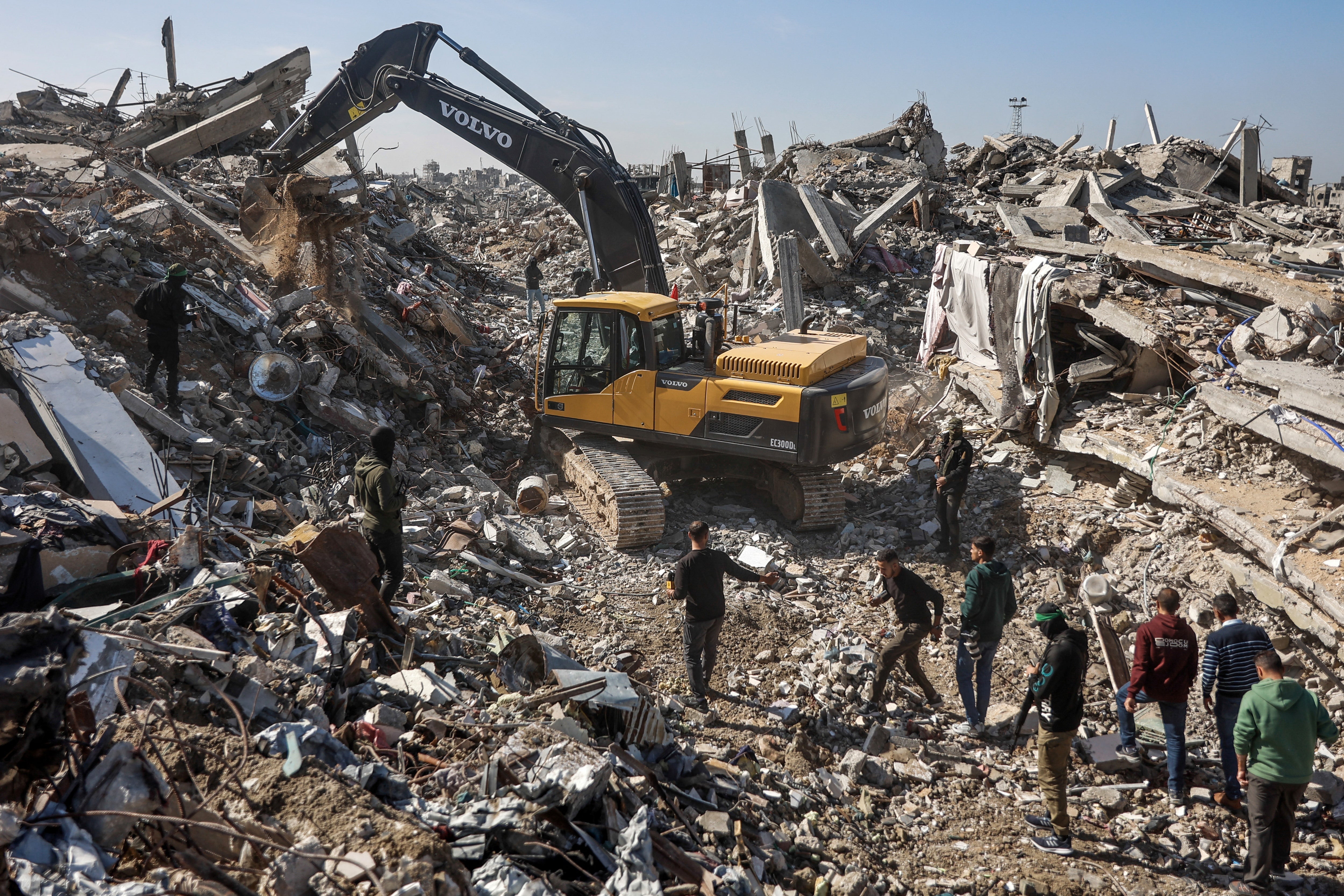 File. Hamas members and Egyptian workers accompanied by Red Cross officials use a digger as they search for the last two remaining hostages under the rubble of the Jabalia refugee camp in northern Gaza on 1 December 2025