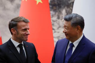 Chinese President Xi Jinping and French President Emmanuel Macron look at each other following a signing ceremony for agreements and contracts at the Great Hall of the People in Beijing