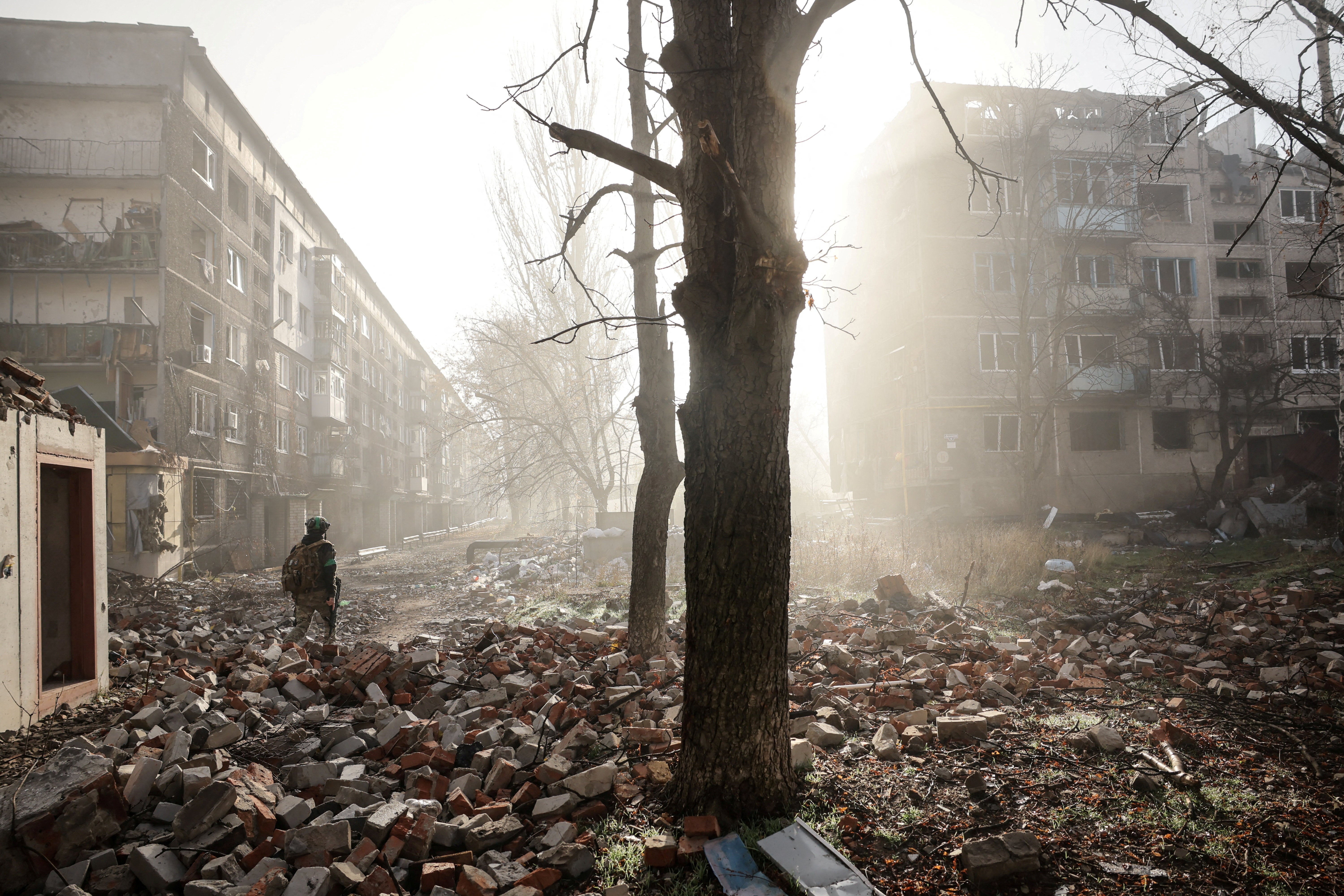 A Ukrainian serviceman walks near apartment buildings damaged by a Russian military strike in the frontline town of Kostiantynivka in Donetsk region.