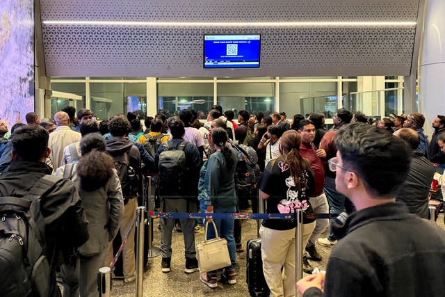 <p>Passengers crowd outside a boarding gate at Indira Gandhi International Airport in New Delhi</p>