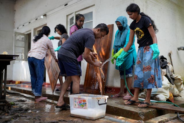 <p>Residents clean doors and furniture after floods following Cyclone Ditwah in Kandy, Sri Lanka</p>