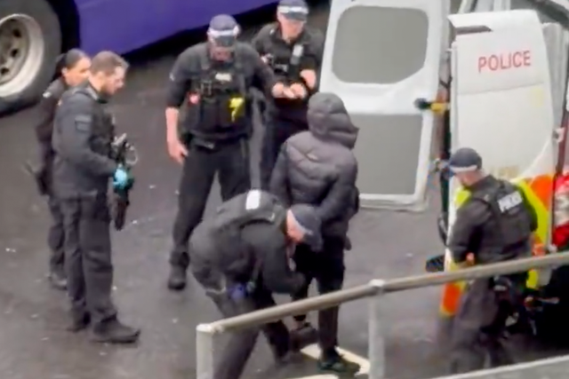 <p>A suspect is held by police at Heathrow on Sunday morning</p>