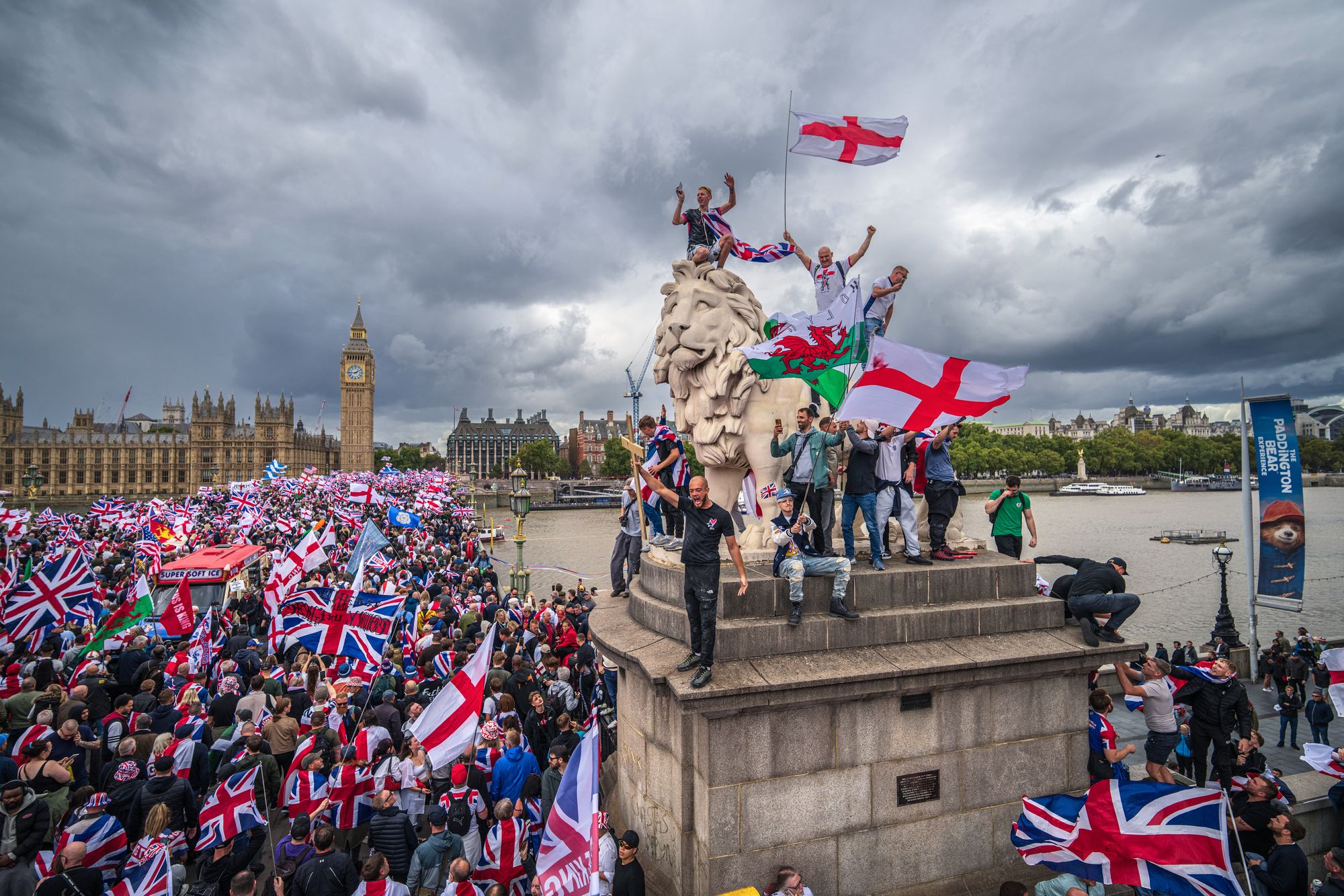 <p>Protesters wave Union Jack and St George’s England flags during the ‘Unite the Kingdom’ rally on Westminster Bridge by the Houses of Parliament on 13 September 2025 in London, England</p>