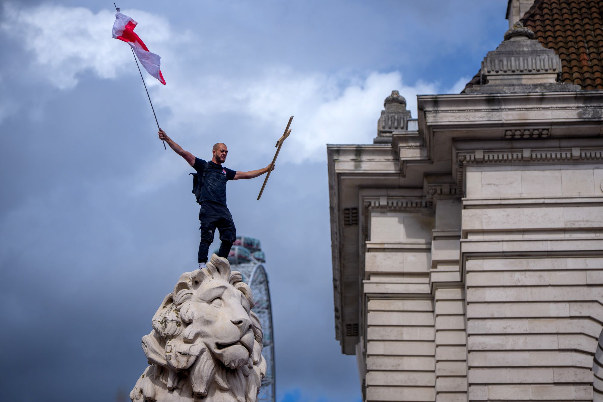 A protester displays the English flag and a wooden cross at Tommy Robinson’s Unite the Kingdom march in September