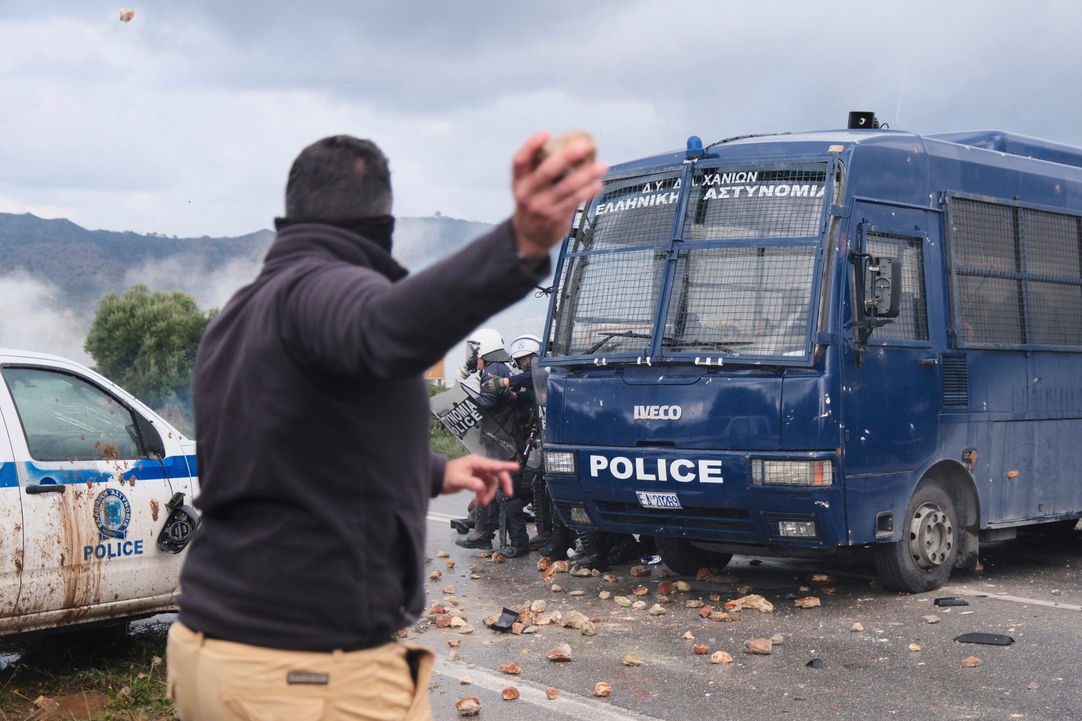 Los agricultores arrojan piedras a la policía durante los enfrentamientos con los agentes que bloqueaban su marcha hacia el aeropuerto de Chania en Creta.