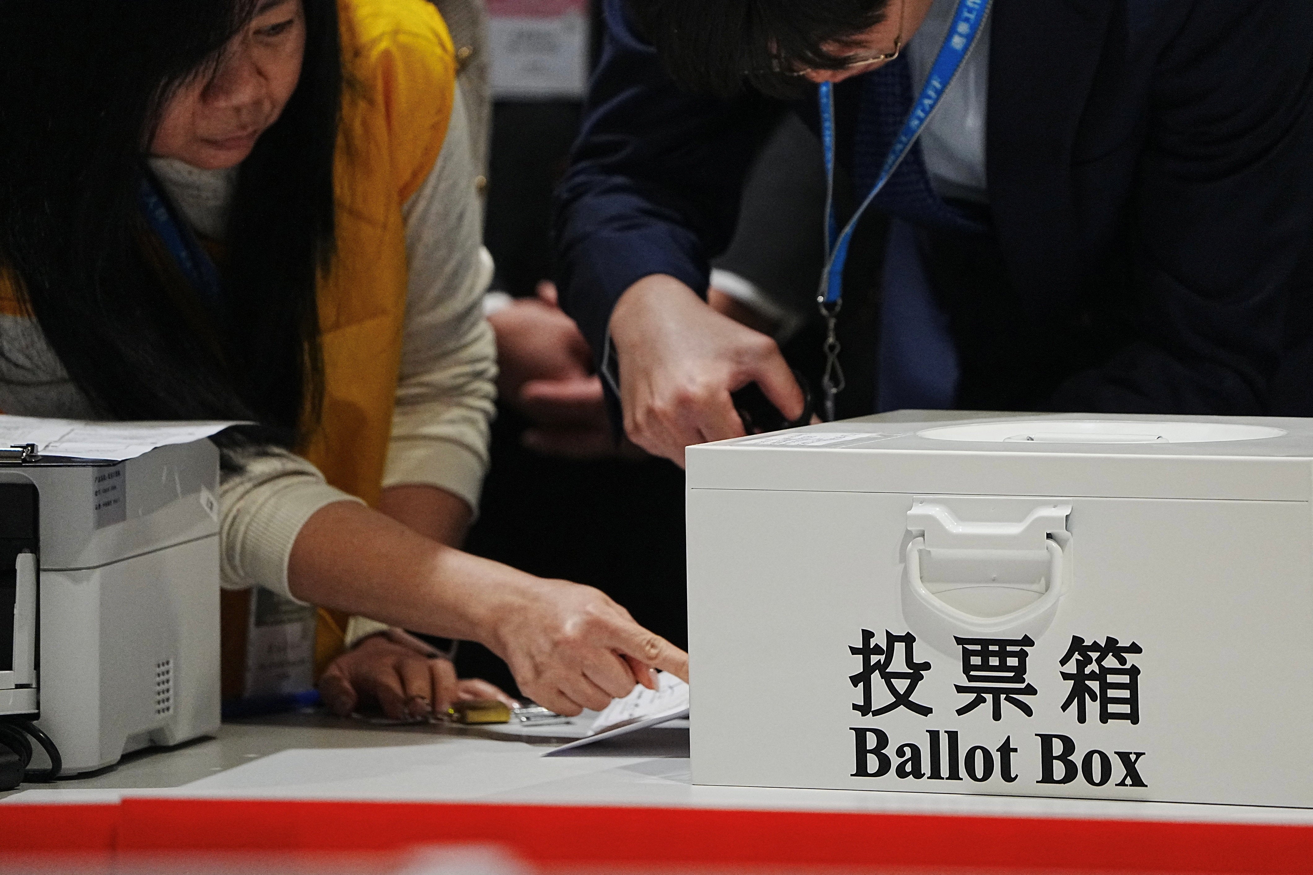 Electoral workers open the ballot box for the legislative election at a vote counting centre in Hong Kong, China, 7 December 2025