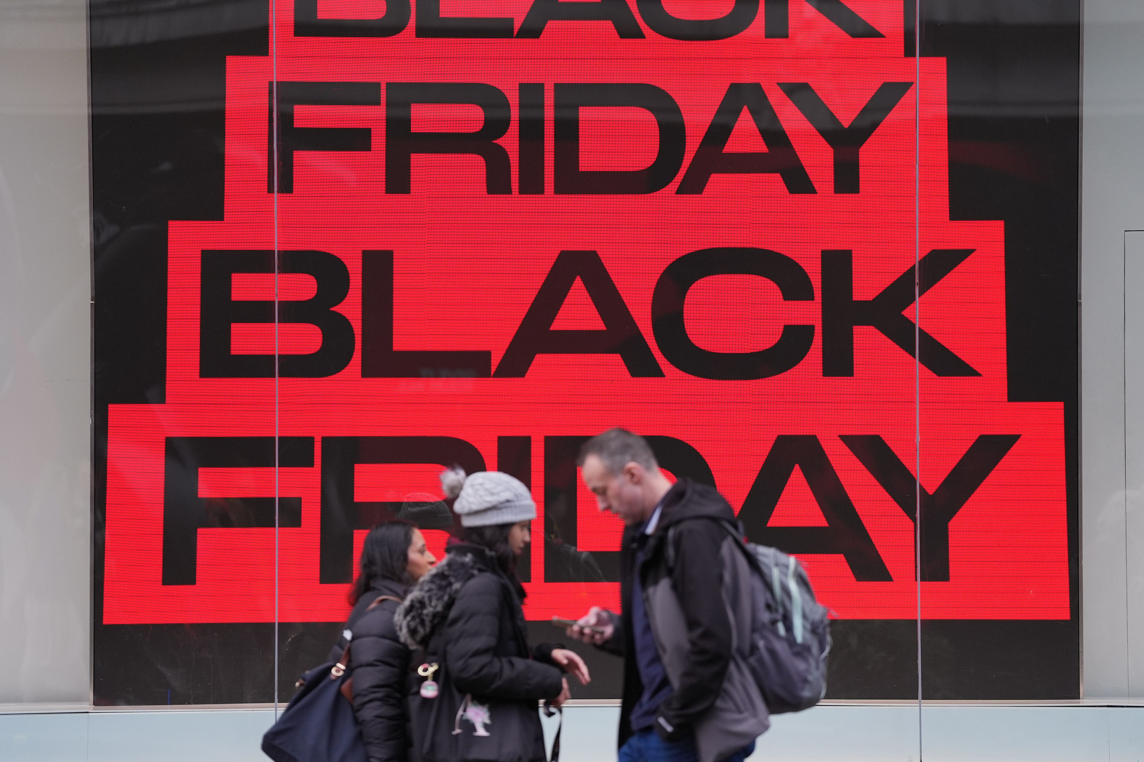 People walking past a Black Friday sign on Oxford Street, London (Yui Mok/PA)
