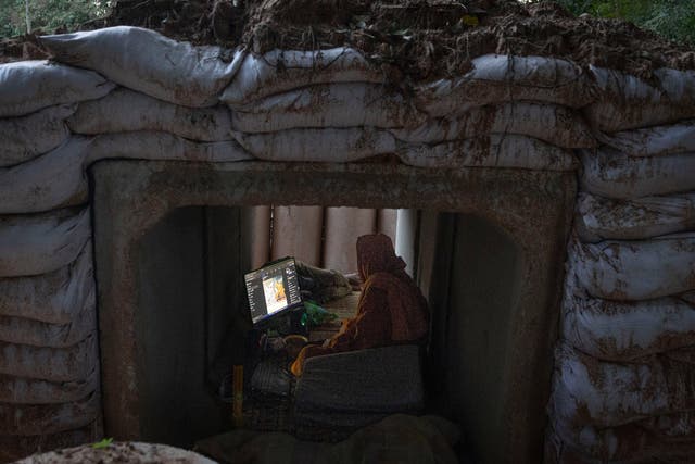<p>A Buddhist monk uses his computer while taking shelter in Buriram province, Thailand</p>