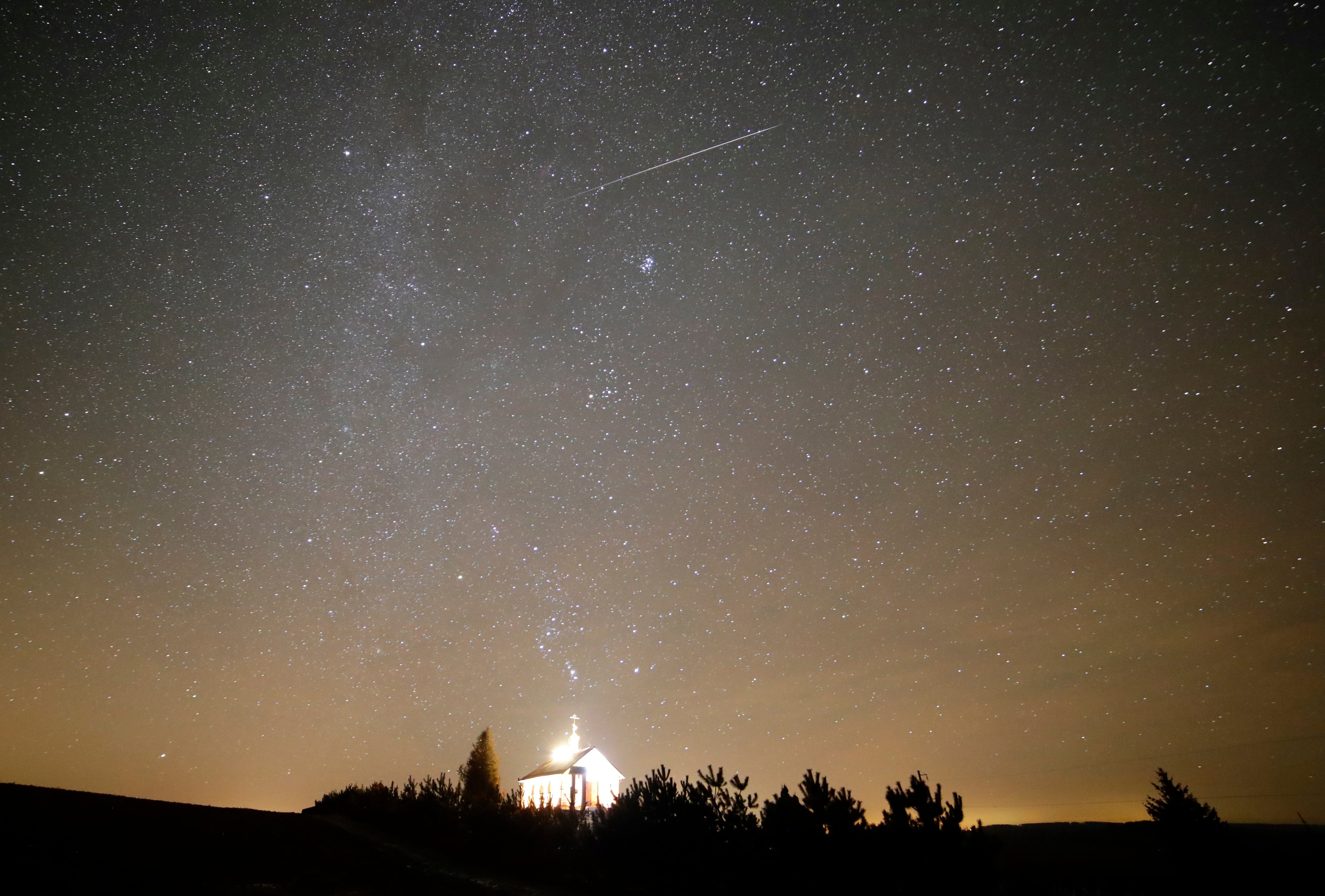 A meteor streaks over an Orthodox church during the annual Geminid meteor shower near the village of Zagorie, some 110 kms. (69 miles) west of Minsk, Belarus, Dec. 13, 2017. (AP Photo/Sergei Grits, File)