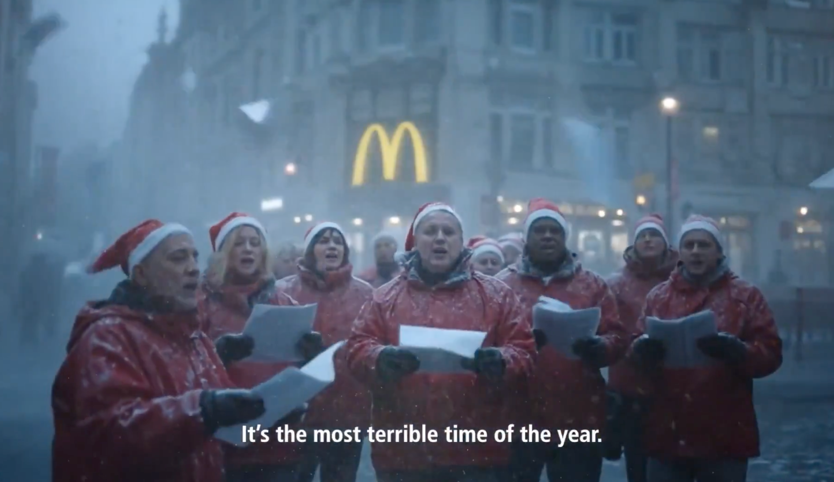 The ad features several AI generated people and families all experiencing mishaps in the lead up to Christmas, including presents falling off car roofs, exploding Christmas trees and carol singers performing in blustery icy conditions