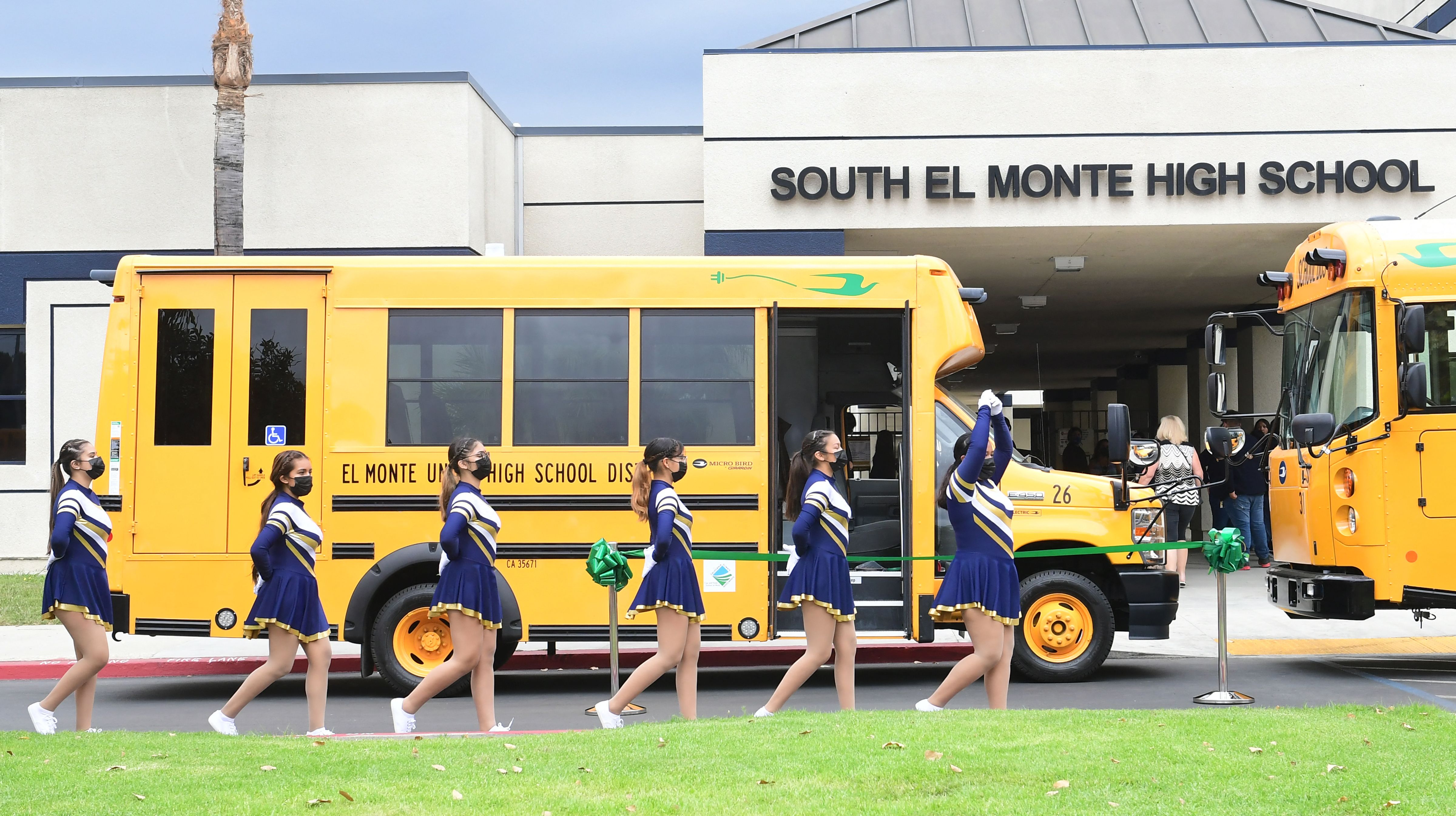 Líderes de torcida da South El Monte High School passam por ônibus escolares em agosto de 2021 em El Monte, Califórnia. Pesquisadores de Harvard dizem que é preciso fazer mais para determinar como a reabertura das escolas durante a pandemia de Covid afetou os alunos marginalizados.
