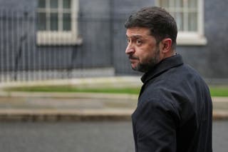 O presidente ucraniano, Volodymyr Zelensky, olha para a mídia enquanto caminha em direção a Downing Street para se encontrar com o primeiro-ministro britânico, Keir Starmer.
