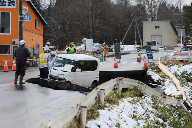 <p>A vehicle is seen on a collapsed road in Tohoku town in Aomori Prefecture on 9 December 2025, following a 7.5 magnitude earthquake off northern Japan </p>