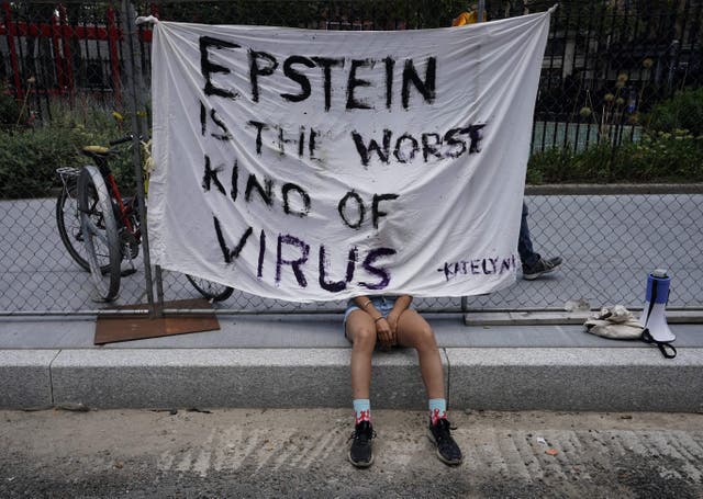 <p>A protester sits outside court as Ghislaine Maxwell was set to make her first court appearance on July 14, 2020 at the US District Court for the Southern District of New York</p>