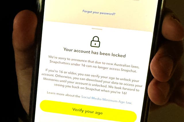 <p>A 13-year-old boy displays a message on his mobile phone from social media platform Snapchat after his account was locked for age verification in Sydney on 9  December 2025</p>