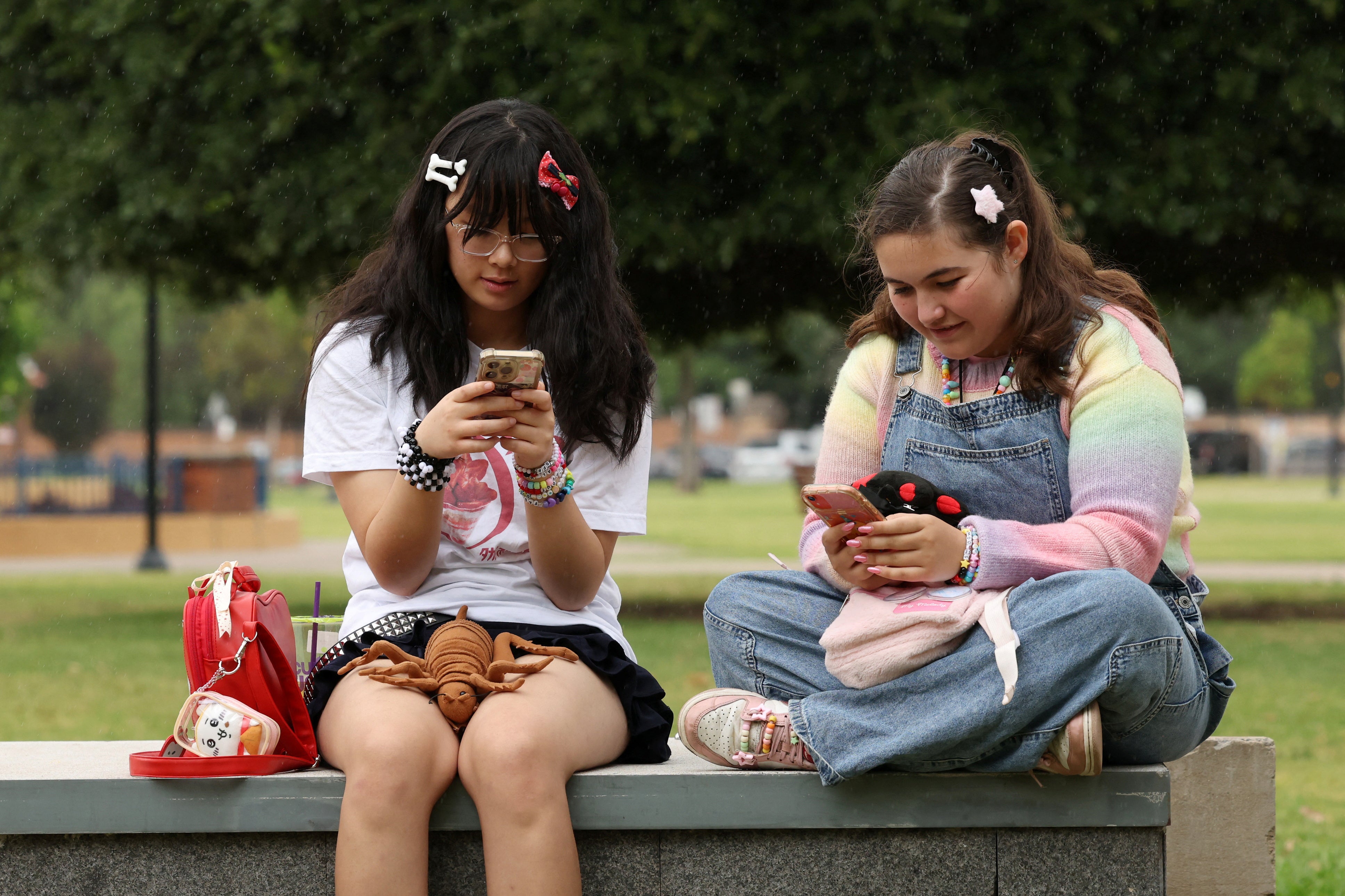 <p>Annie Wang, 14, and Ayris Tolson, 15, pose after an interview discussing Australia’s social media ban for users under 16, which is scheduled to take effect on December 10, in Sydney (REUTERS/Hollie Adams)</p>