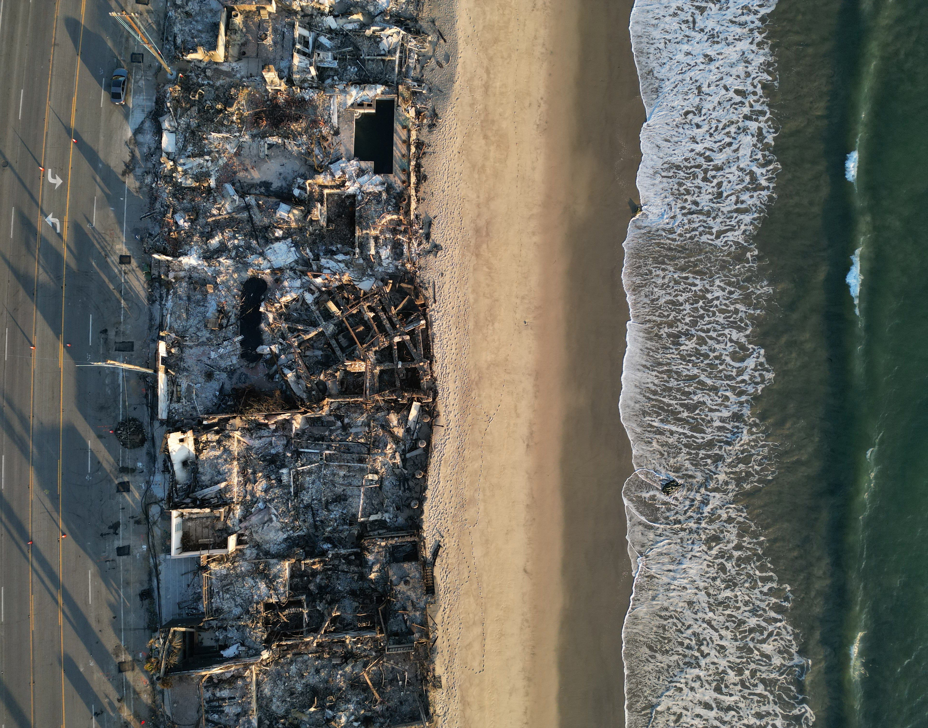 This aerial picture shows the remains of oceanfront homes destroyed in the Palisades Fire along the Pacific Coast Highway in Malibu, California, on January 17, 2025