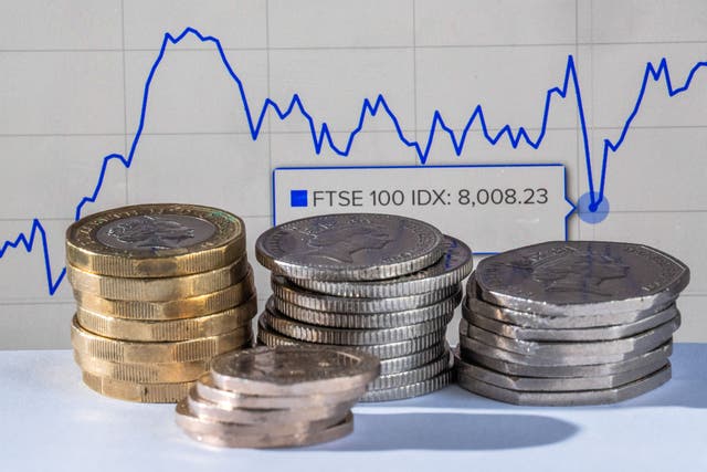 Money is stacked in front of the London Stock Exchange website (Danny Lawson/PA)