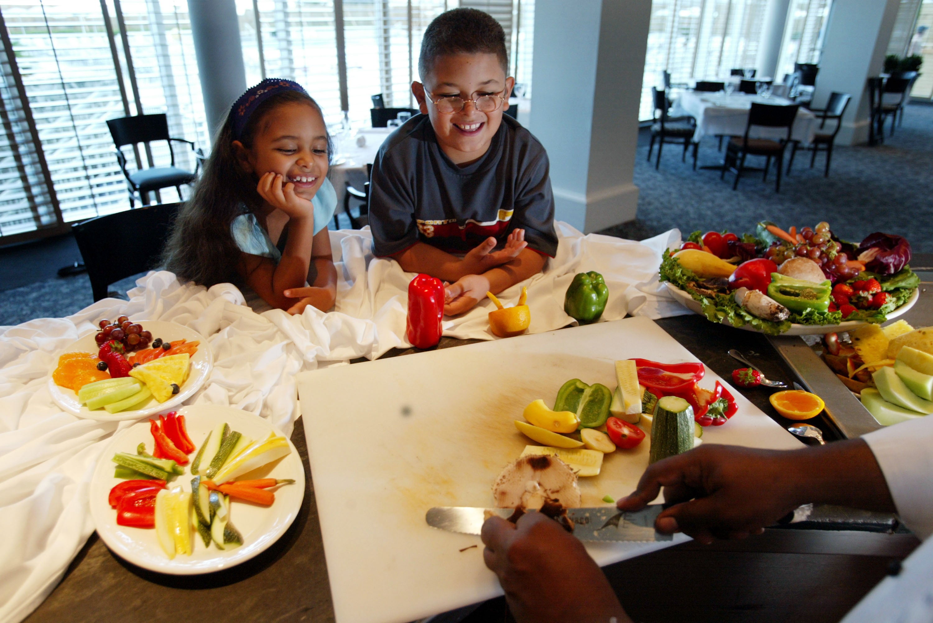 <p>Siblings watch a chef prepare a healthy snack in July 2002 in Miami Beach, Florida.  Vegetarian kids got more gut-boosting fiber, iron, folate and vitamin C than omnivores, and both vegan and vegetarian children had better heart health</p>