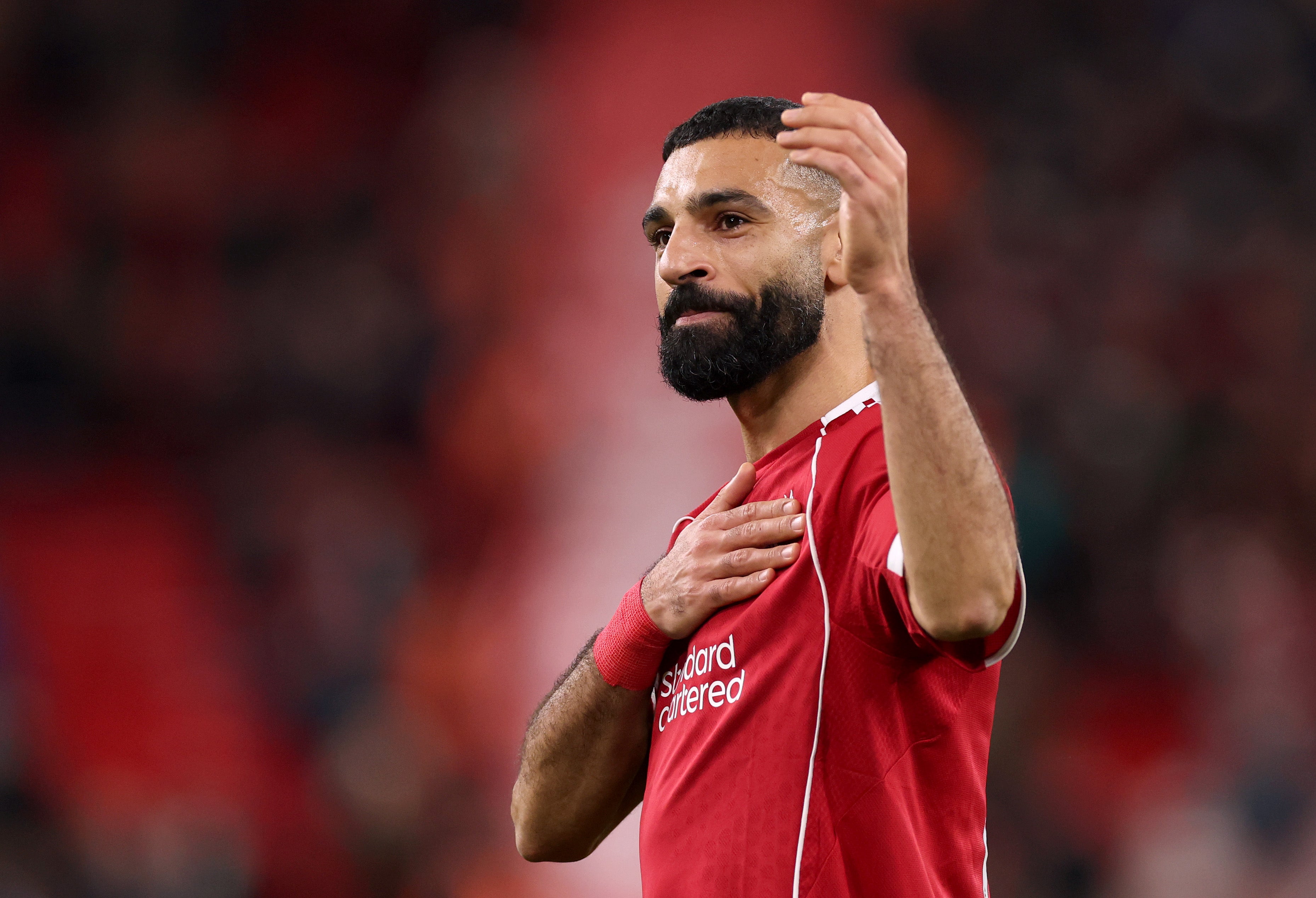 <p>Mohamed Salah touches the Liverpool club crest on his shirt after the final whistle at Anfield</p>