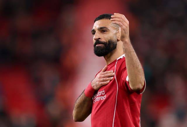 <p>Mohamed Salah touches the Liverpool club crest on his shirt after the final whistle at Anfield</p>
