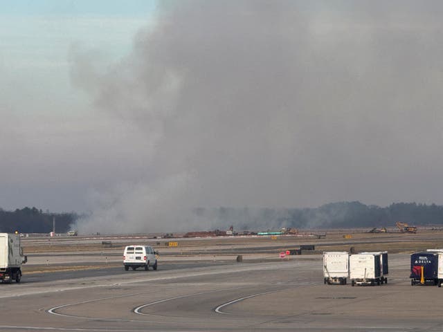 <p>Smoke rising from a small brush fire that was ignited when a United Airlines flight lost engine power</p>