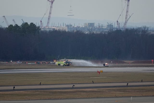 <p>An emergency vehicle puts out a brushfire near the tarmac after United Airlines Flight 803's engine failed </p>