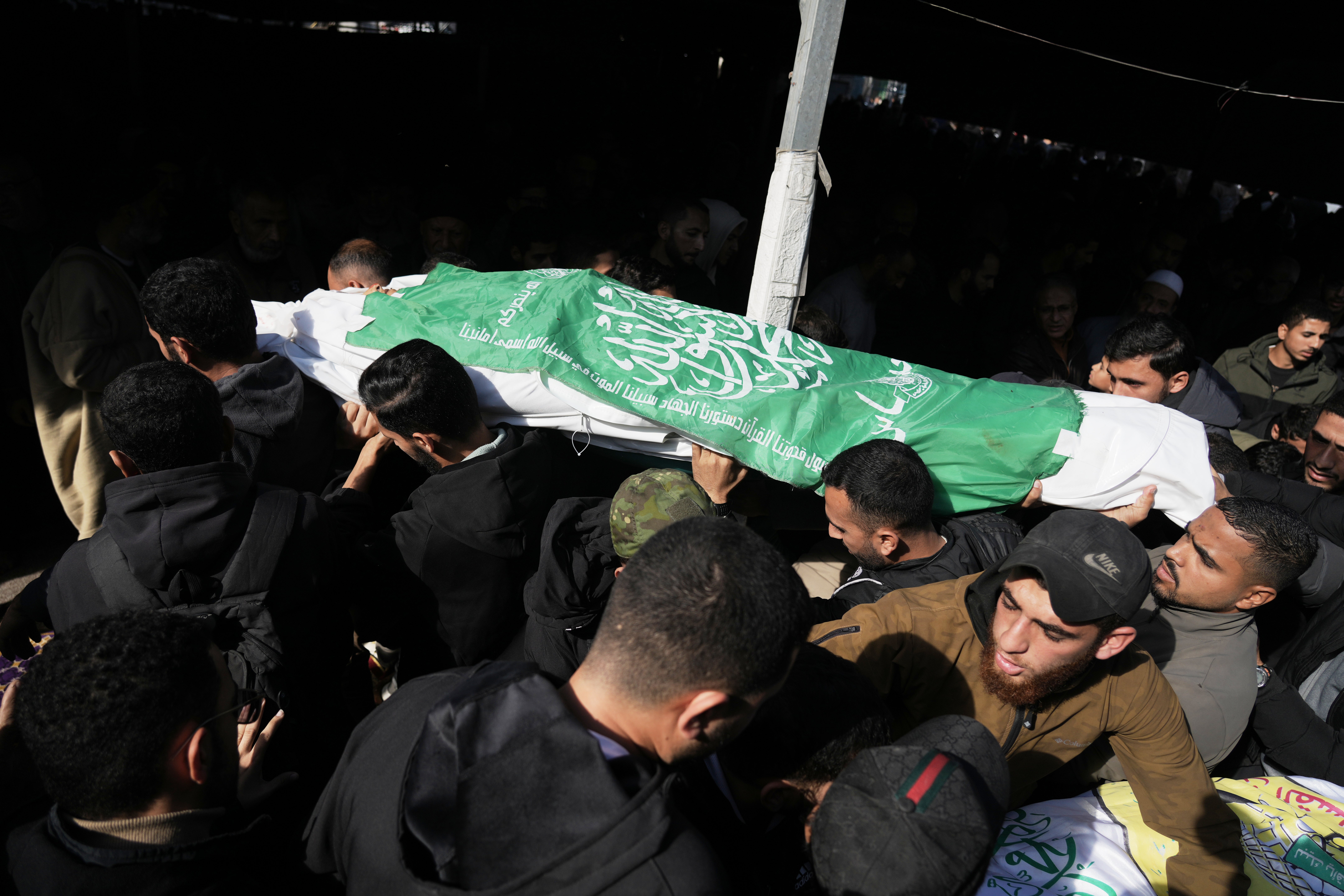 Palestinians carry the body of a Hamas militant draped in the group's flag, who was killed in an Israeli army strike