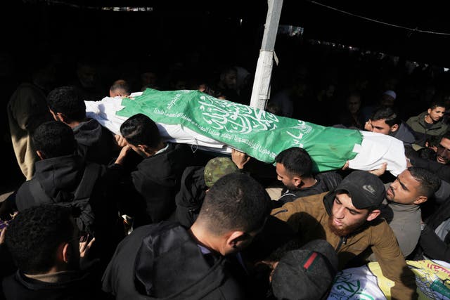 <p>Palestinians carry the body of a Hamas militant draped in the group's flag, who was killed in an Israeli army strike</p>