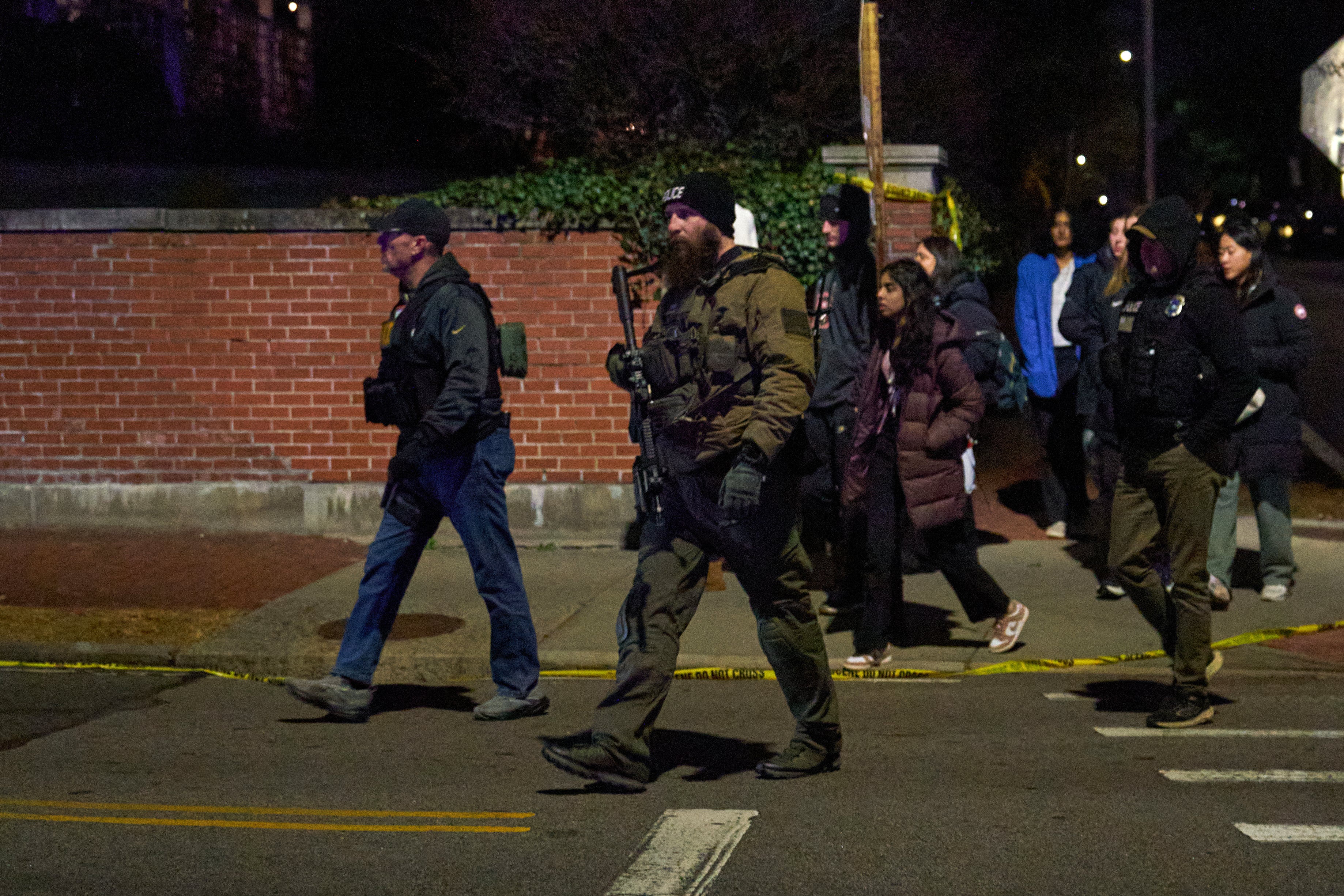 Law enforcement officers escorted students near the Barus & Holley engineering building at the Brown University campus December 13