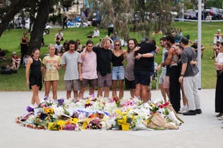 People embrace after laying flowers at a memorial outside Bondi Pavilion at Sydney's Bondi Beach, Monday