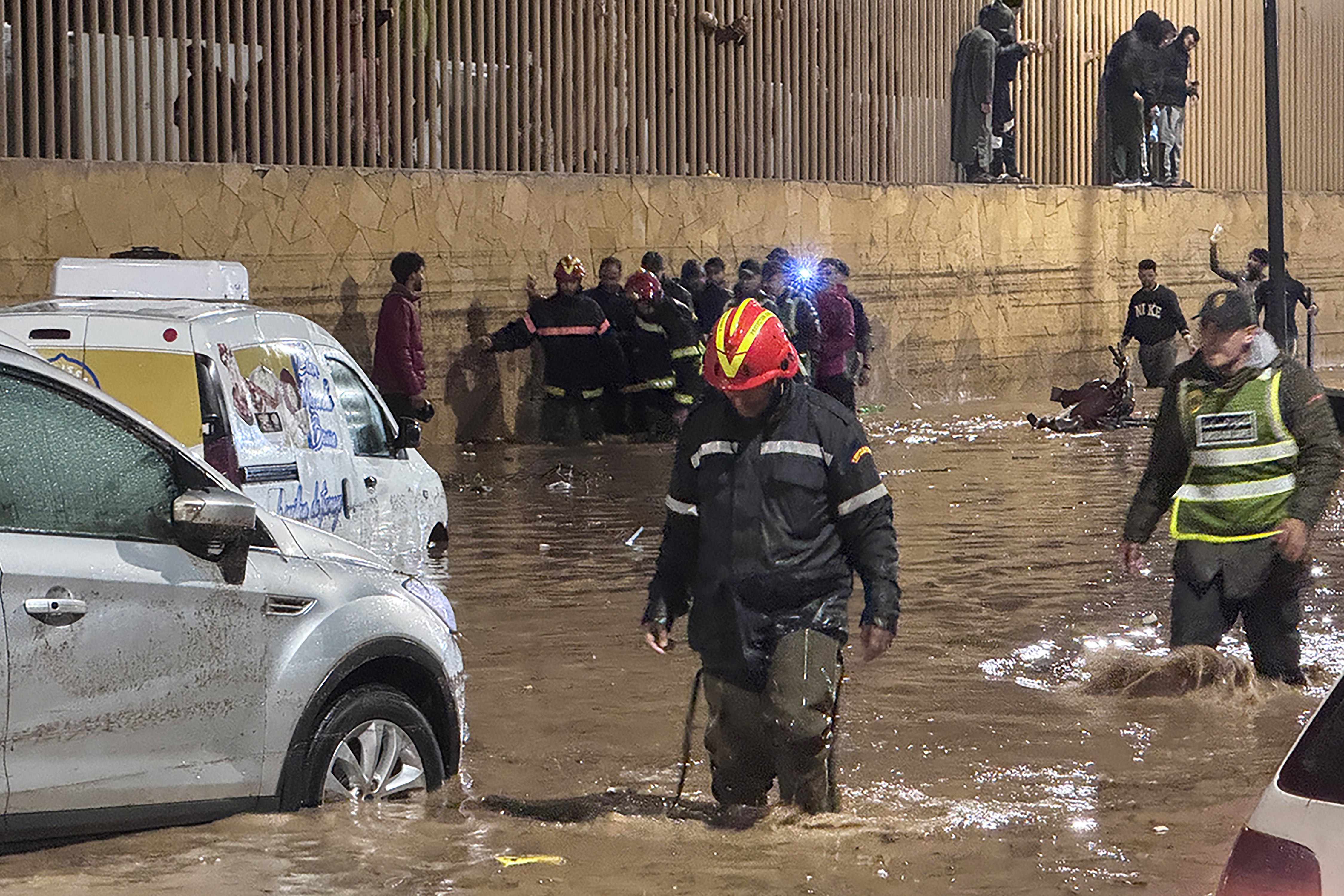 <p>People wade through a street after a flash flood in Safi on December 14, 2025</p>