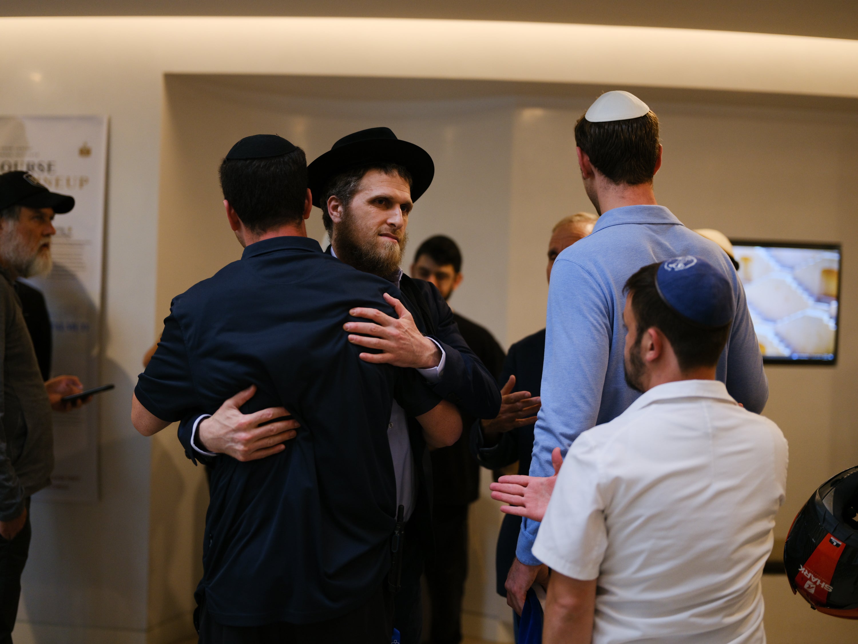 Members of the Jewish community hug each other at Jewish community center, Chabad of Bondi at Bondi Beach