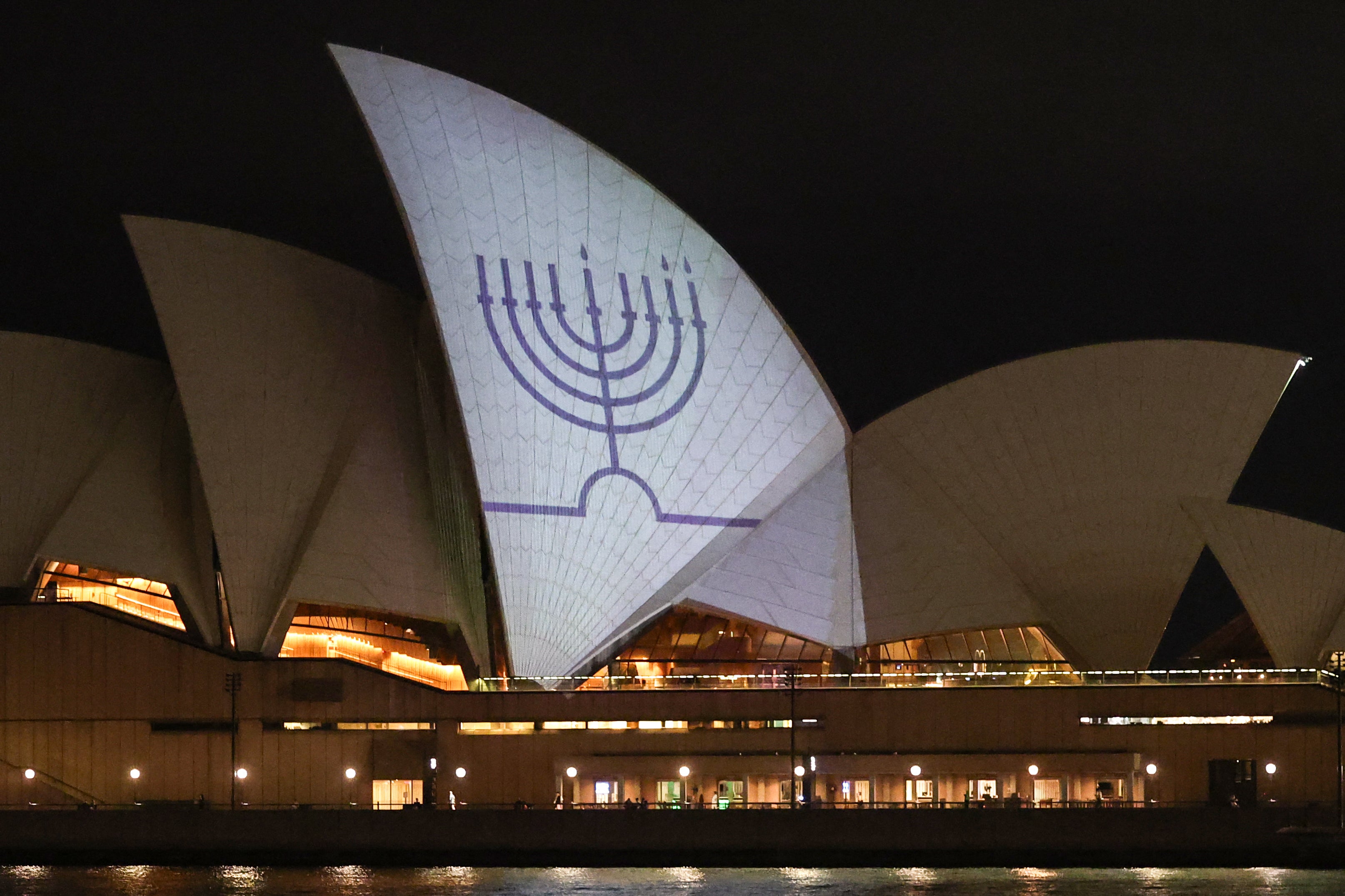 A Hanukkah menorah is projected onto the sails of the Sydney Opera House in memory of the victims of a shooting at Bondi Beach
