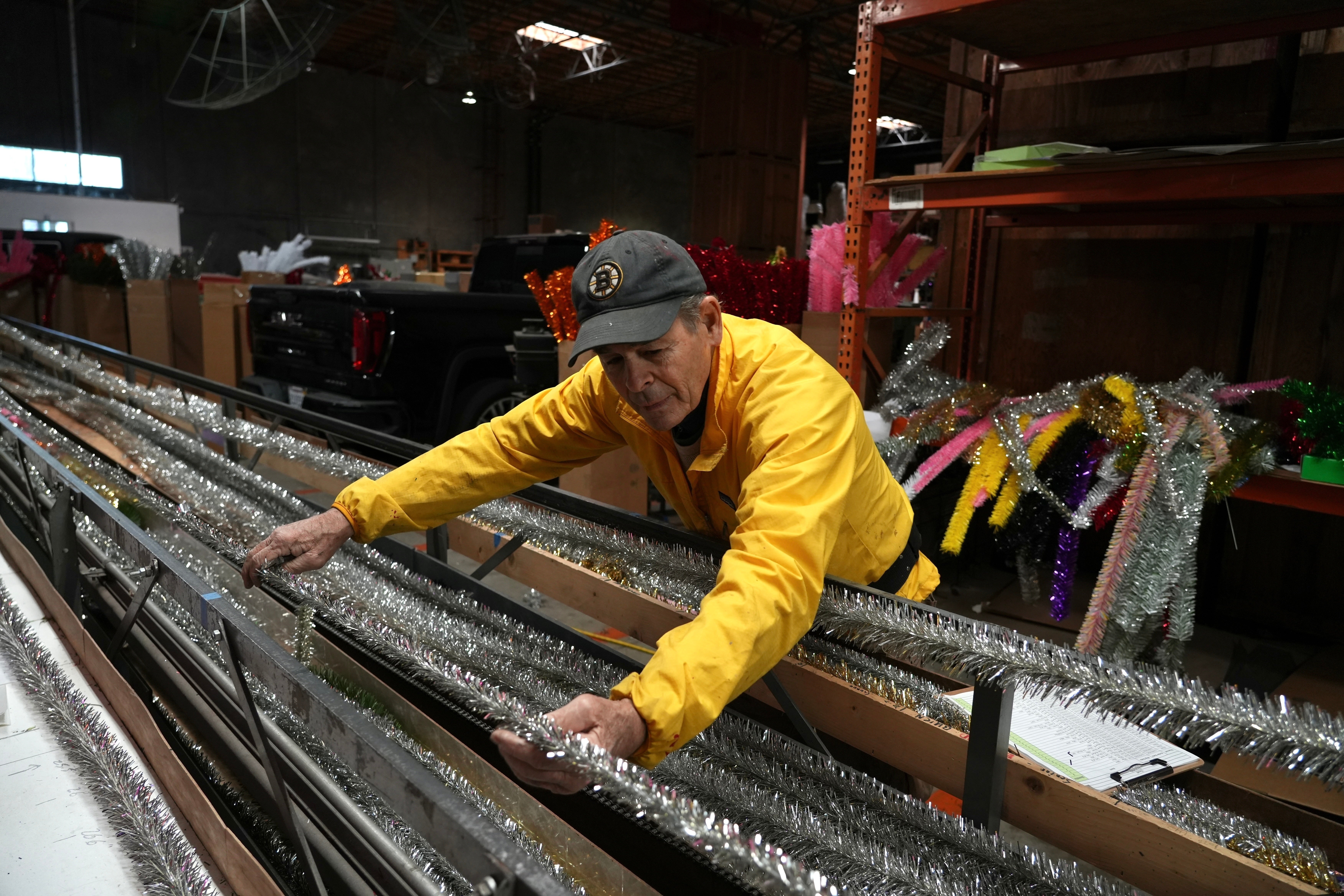 Mark Latino, CEO of Lee Display, works with a machine that makes tinsel brush for artificial Christmas trees at the company's warehouse