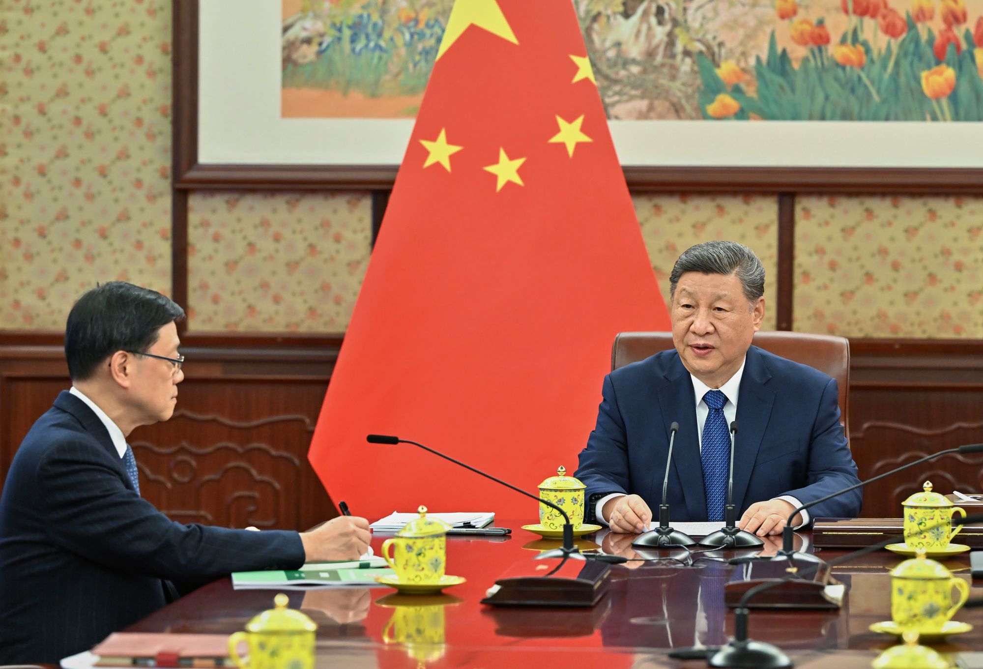 Chinese president Xi Jinping, right, talks to Hong Kong's chief executive John Lee in Beijing
