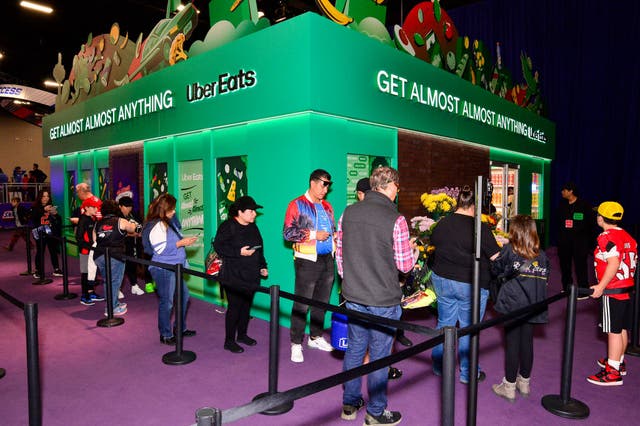 <p>People in line at an Uber Eats kiosk. Some 21 states and Washington DC have joined a Federal Trade Commission lawsuit against the ride share app</p>