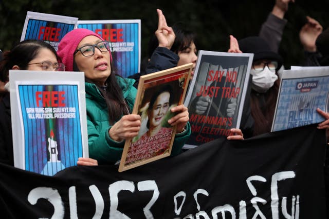 <p>A Myanmar protesters residing in Japan shows off the portrait of Myanmar's detained former leader Aung San Suu Kyi</p>